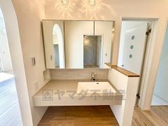 オシャレなホテルライクな洗面台、洗濯機置き場、バスルームが連なっている、生活導線の考えられた作りになっています。