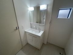 三面鏡つき洗面台。鏡裏にたっぷりとした収納スペースがあります。鏡を閉めてしまえば小物は見えないため、スッキリとした印象の洗面台にできます。