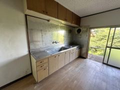 窓から自然光が差し込む明るいキッチン。収納棚を豊富に備えており、調理器具や食器もすっきり整理できる使い勝手の良い空間です。