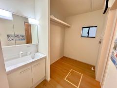 洗面室横にはパイプ付き枕棚を設置。タオルや衣類をすっきり収納でき、家事動線にも配慮された便利な空間です