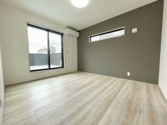 バルコニーに面した大きな窓から光が差し込む明るい洋室