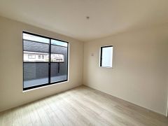 ベランダに面した大きな窓から光が差し込む明るい洋室