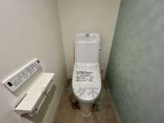 温水洗浄機付トイレです。落ち着いた色のアクセントクロスを使用しています。