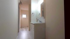 同仕様写真。洗面台、洗濯機置き場、バスルームが連なっている、生活導線の考えられた作りになっています。