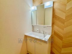 三面鏡つき洗面台。収納も一体型になっているので、ドライヤーやヘアアイロンの置き場に困りませんね。