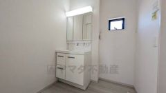 洗面台、洗濯機置き場、バスルームが連なっている、生活導線の考えられた作りになっています。三面鏡つき洗面台で収納も一体型になっているので、ドライヤーやヘアアイロンの置き場に困りませんね。