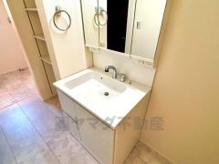 便利な三面鏡の洗面台です。すぐ近くに収納があるので散らかりがちなバスタオルや清掃用品、化粧品や予備のシャンプー等もきれいに整頓できますね。